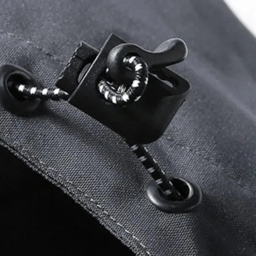 Black drawcord toggle with grommets on gray jacket hood, close-up detail | Chaps London