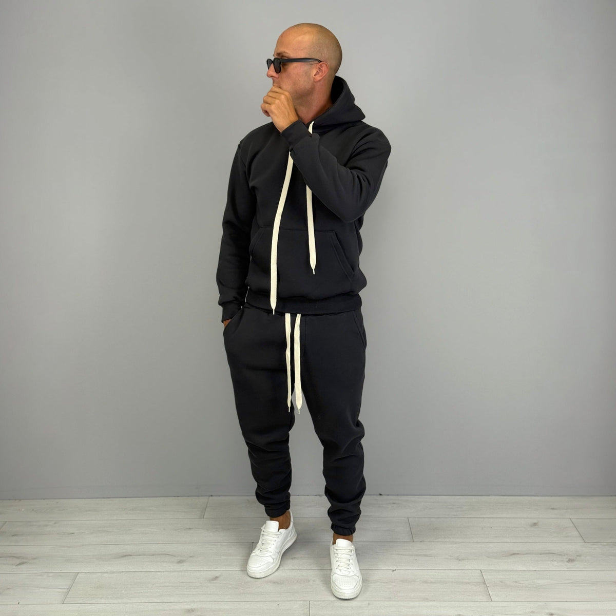 Man wearing black hoodie tracksuit with cuffed joggers and white sneakers | Chaps London
