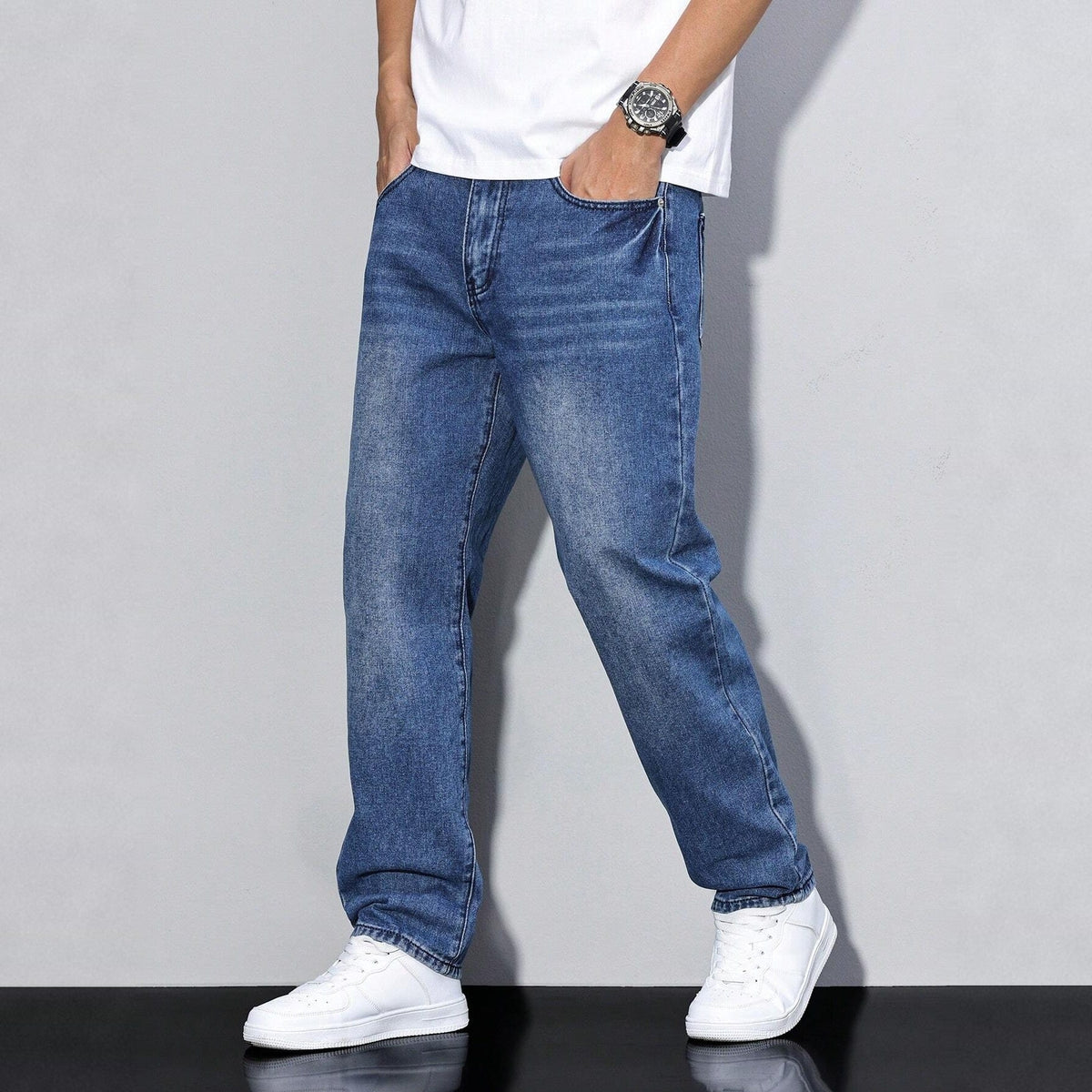 Man wearing faded blue wide-leg denim jeans with white sneakers | Chaps London
