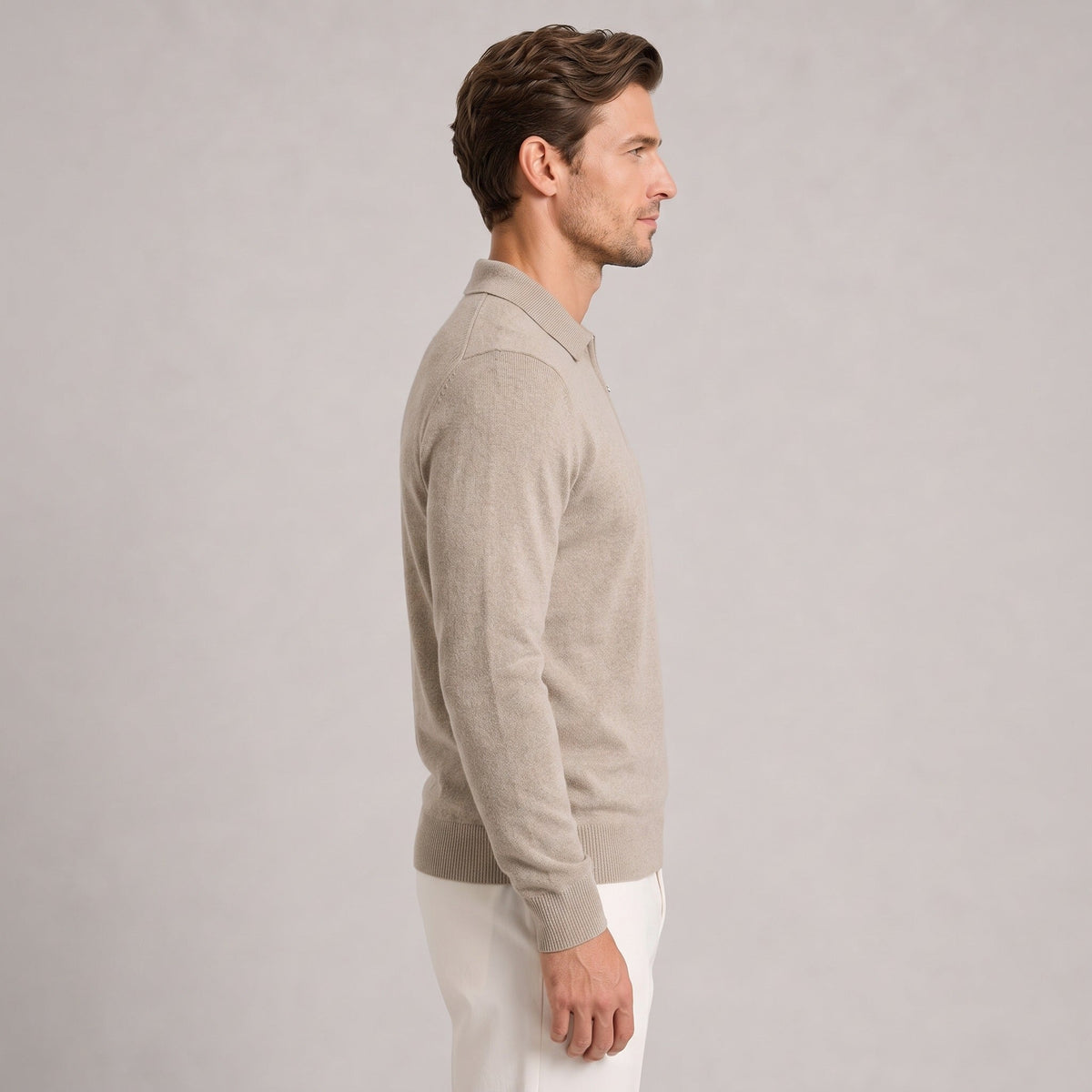 Man wearing beige fine-knit quarter-zip polo jumper with white trousers, side view | Chaps London