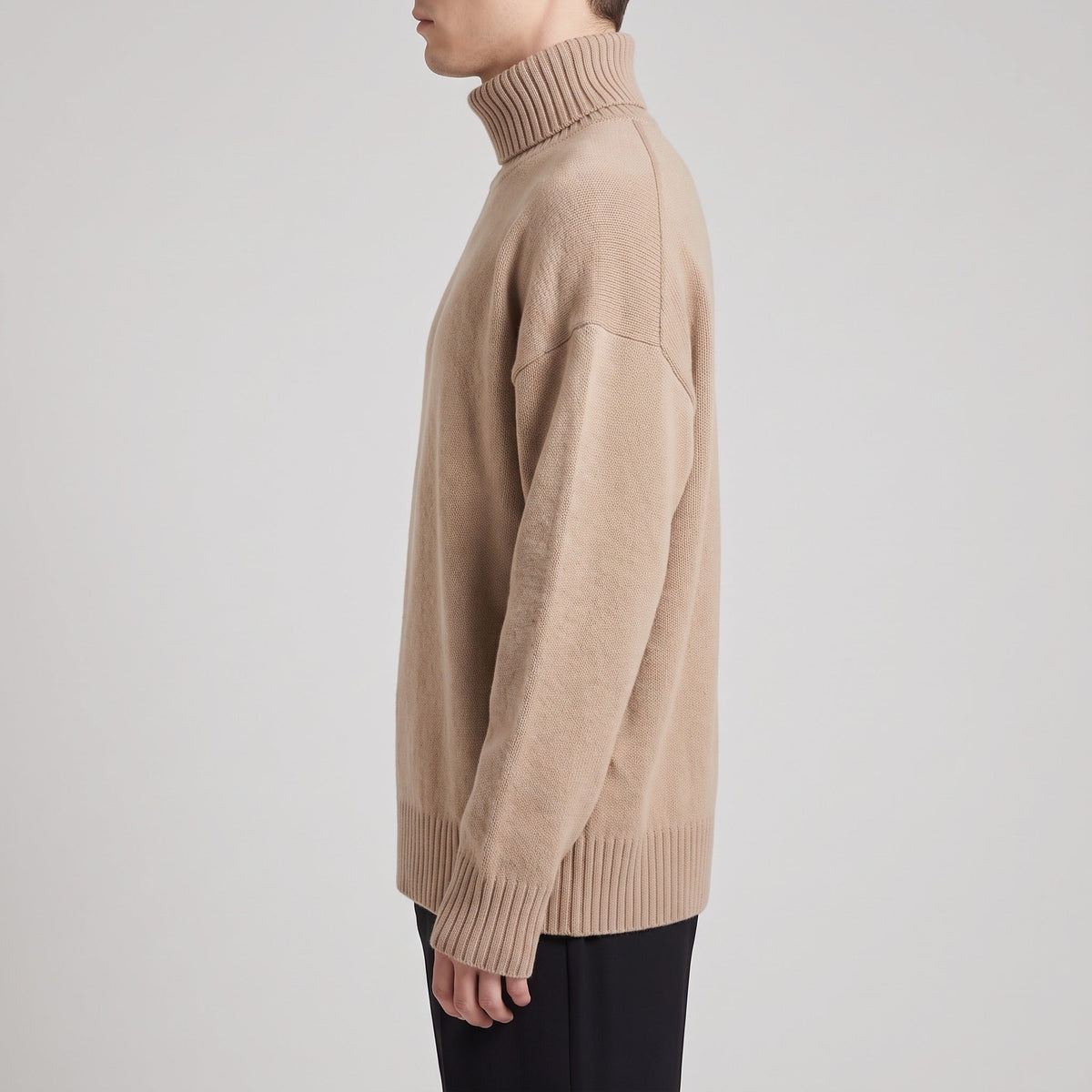Beige oversized roll neck jumper worn by man, side view | Chaps London