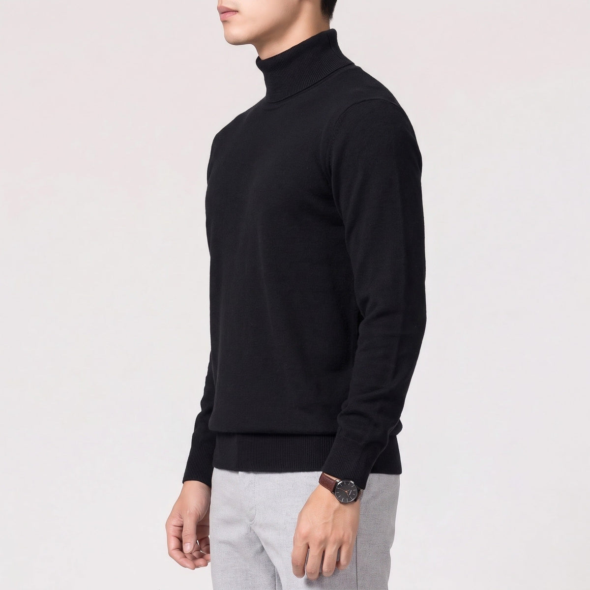 Man wearing black fine knit turtleneck sweater with grey trousers, side view | Chaps London