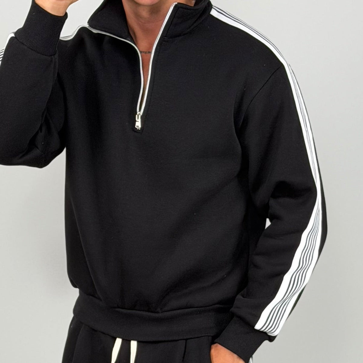 Man wearing black half zip tracksuit top with white striped sleeves | Chaps London