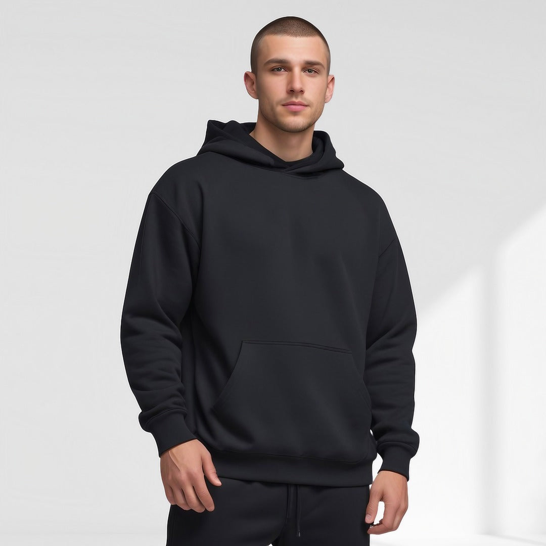 Men's oversized drop-shoulder hoodie in black, worn, front view