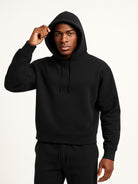 Men's relaxed-fit hoodie in black, worn, front view