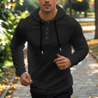 Men's henley hoodie with a button placket in black, worn, front view