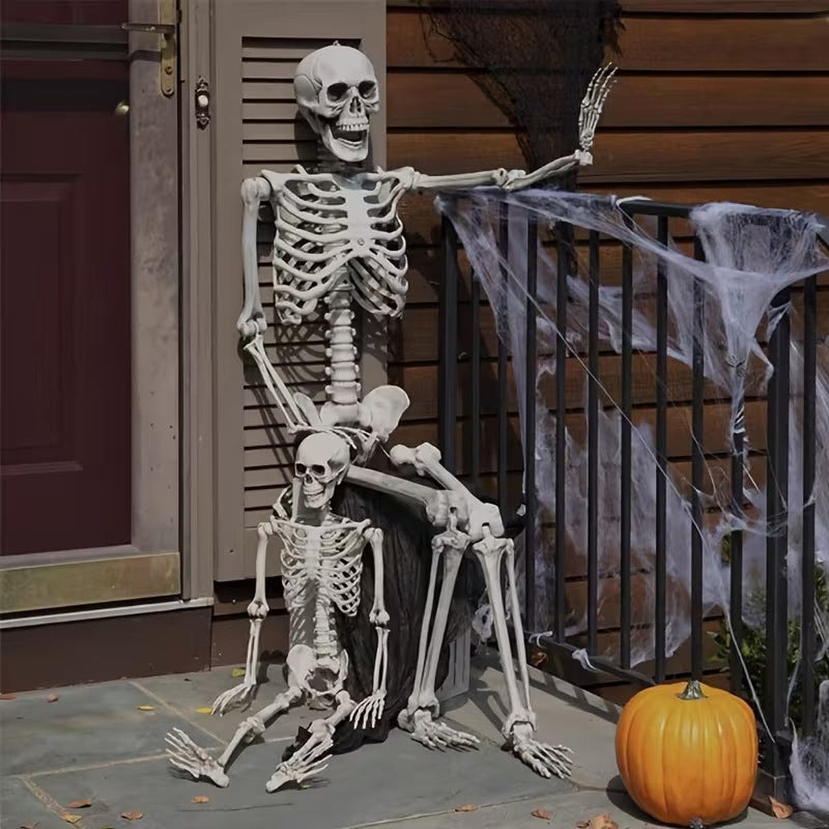 Skeleton on the porch for Halloween, with a smaller skeleton on its lap