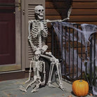 Skeleton on the porch for Halloween, with a smaller skeleton on its lap