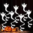 Hanging ghosts above pumpkins as Halloween decoration