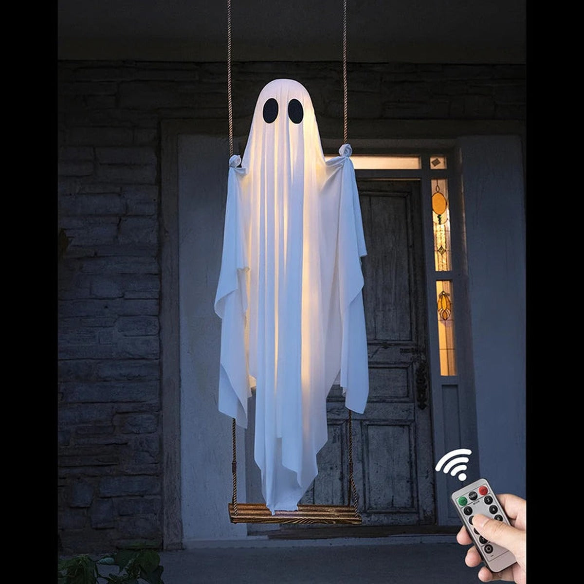 Light-up Halloween ghost on a wooden swing by the front door, with remote control