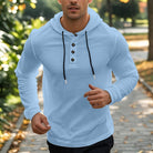 Men's henley hoodie with a button placket in light blue, worn, front view
