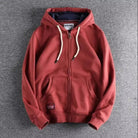 Brick red zip-up hoodie with a navy-lined hood and kangaroo pocket, laid flat | Chaps London