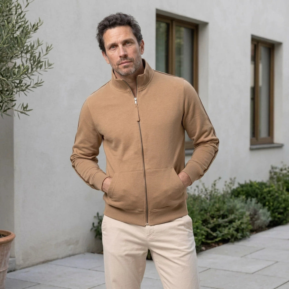 Man wearing a camel stand-collar zip-up sweatshirt in a courtyard, both hands in the front pockets | Chaps London