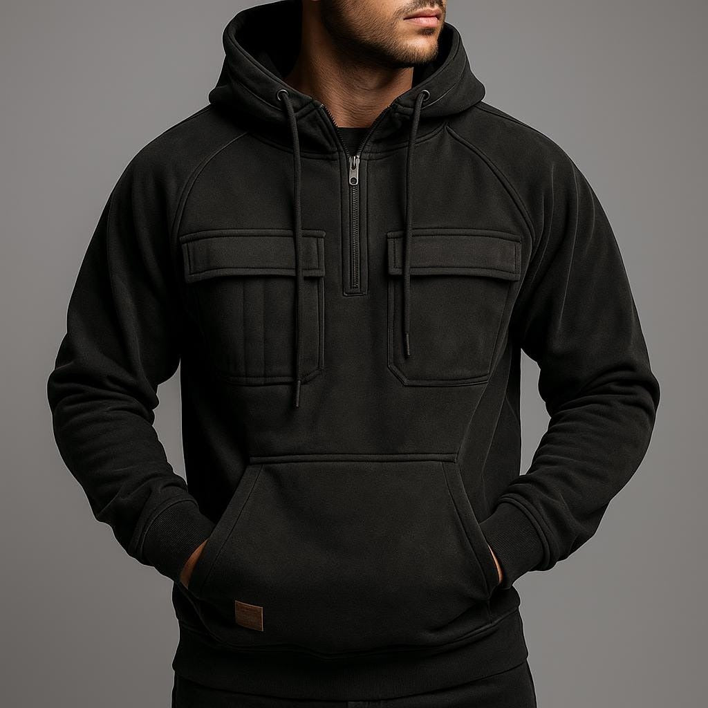 Men's half-zip utility hoodie with chest pockets in black, worn, front view