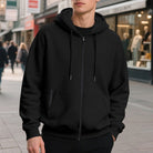 Men's oversized zip-up hoodie in black, worn, front view