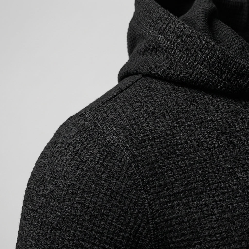 Men's slim-fit gym hoodie in black, close-up of the textured fabric at the shoulder and hood