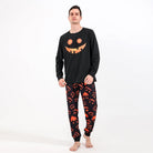 Man wearing the black Halloween pyjamas with a jack-o'-lantern face