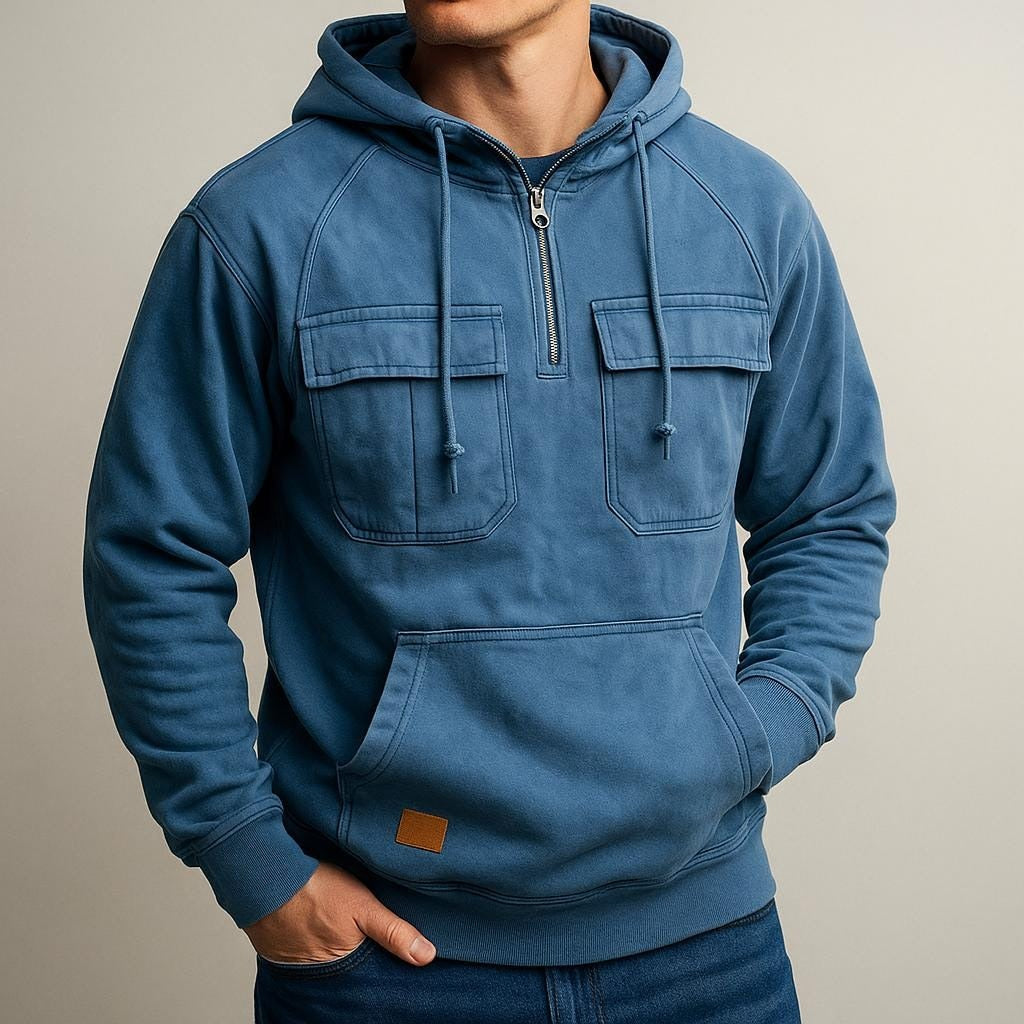 Men's half-zip utility hoodie with chest pockets in blue, worn, front view