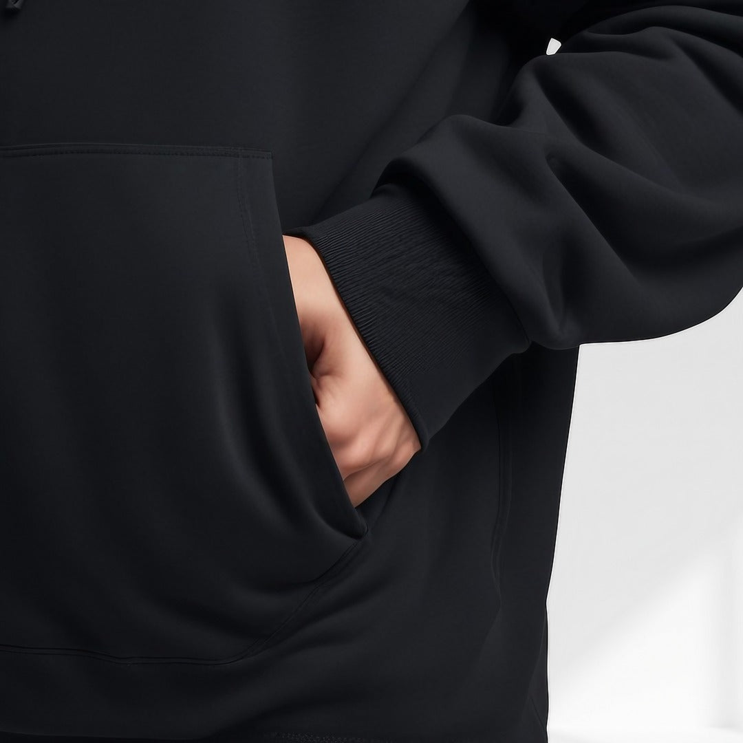 Men's oversized drop-shoulder hoodie in black, close-up of the kangaroo pocket