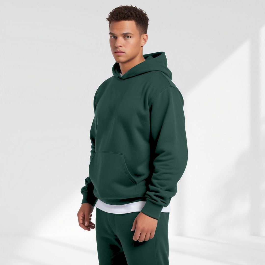 Men's oversized drop-shoulder hoodie in dark green, worn, front view
