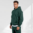 Men's oversized drop-shoulder hoodie in dark green, worn, front view