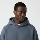 Men's heavyweight hoodie in washed blue, close-up of the hood and the neckline
