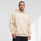 Men's oversized drop-shoulder hoodie in cream, worn, front view