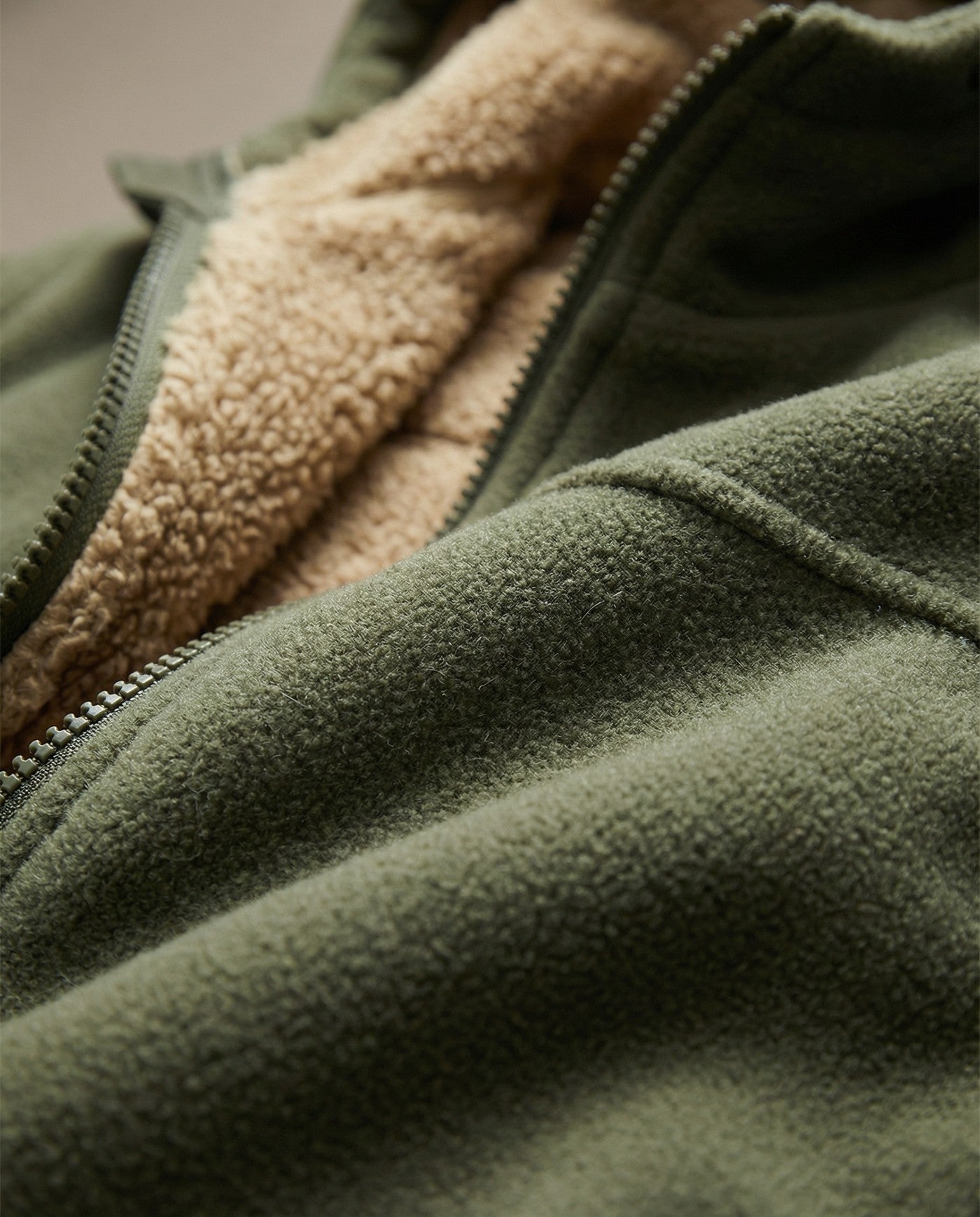 Men's sherpa-lined zip-up fleece in army green, close-up of the sherpa lining and the zip
