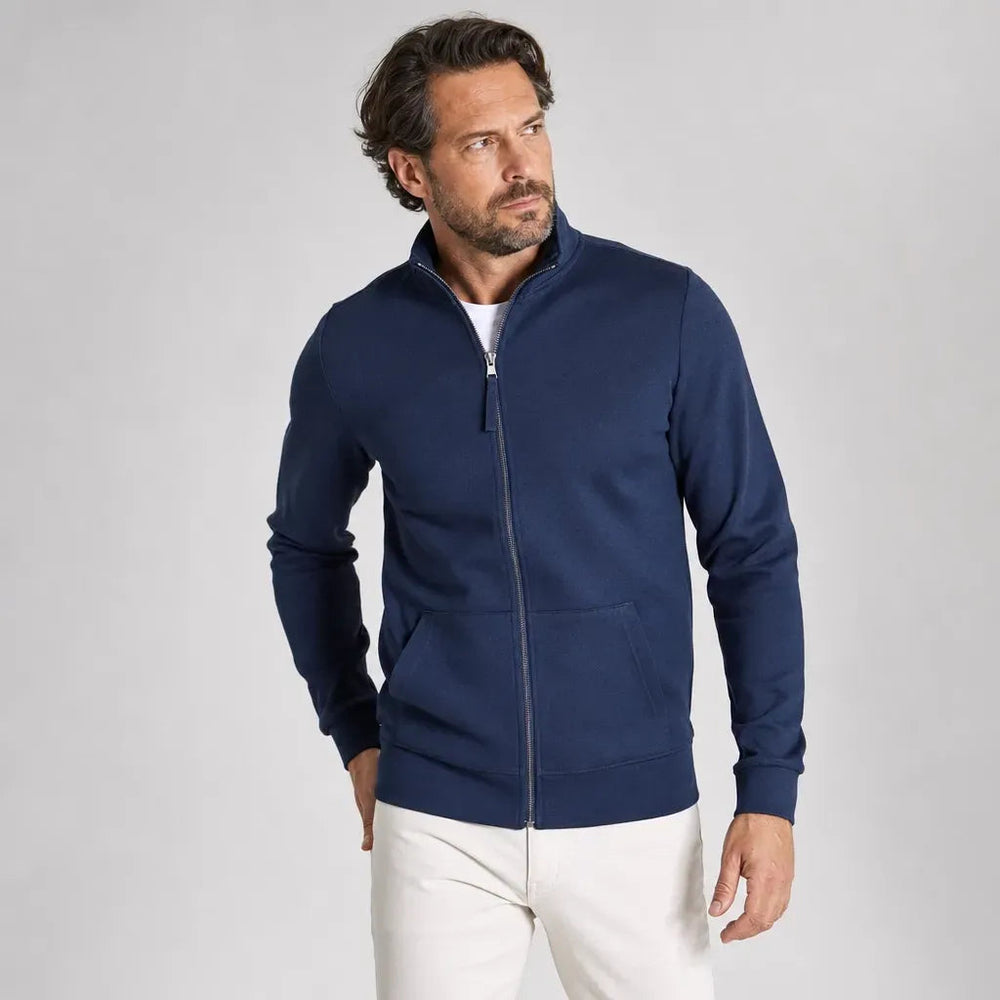 Man wearing a navy zip-up sweatshirt over a white T-shirt with light trousers | Chaps London