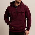 Men's half-zip utility hoodie with chest pockets in wine red, worn, front view