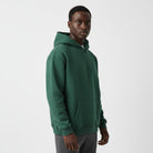 Men's heavyweight hoodie in deep green, worn, front view