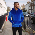 Men's velvet hoodie in royal blue, worn by a model on a street