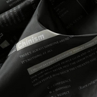 Black fabric close-up with printed text design, folded garment detail shown | Chaps London