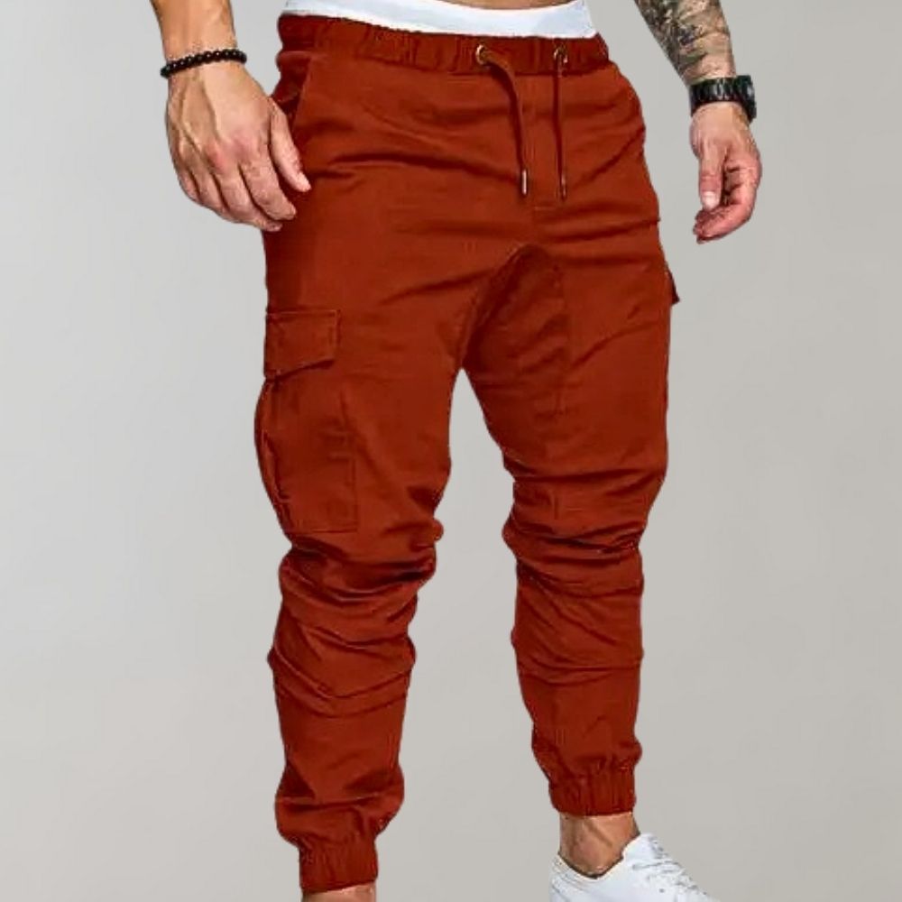 Man wearing rust-colored cargo joggers with drawstring waist and side pocket | Chaps London
