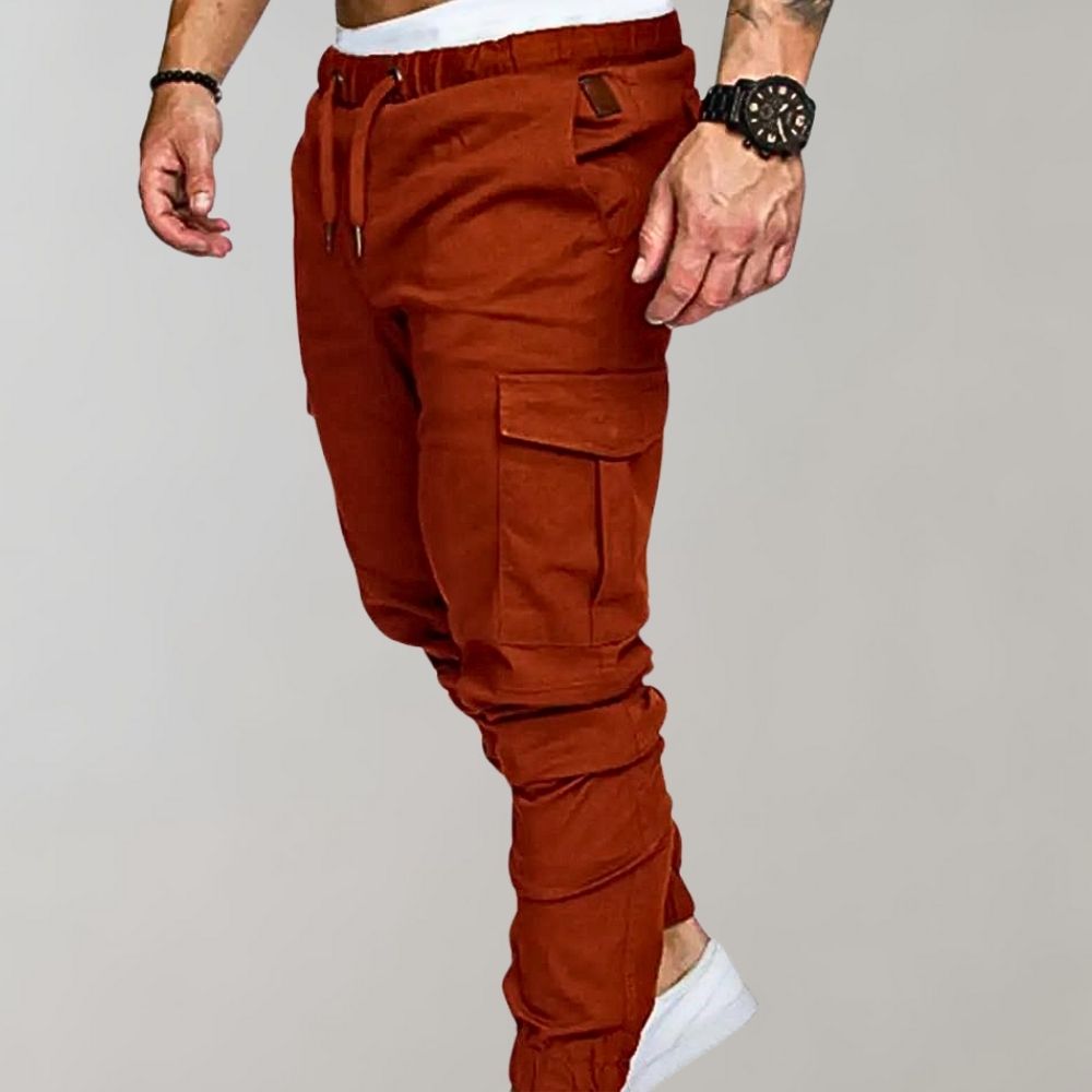 Rust orange cargo joggers with drawstring waist, worn by man walking | Chaps London