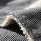 Folded gray corduroy fabric with cream sherpa lining, close-up detail shot | Chaps London
