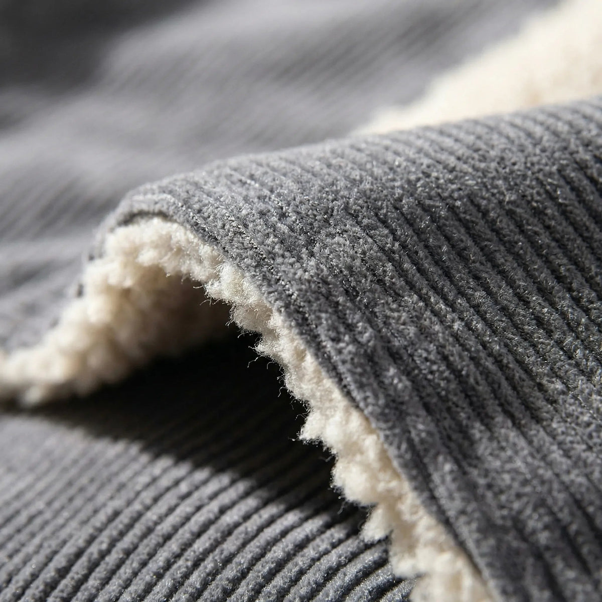 Folded gray corduroy fabric with cream sherpa lining, close-up detail shot | Chaps London