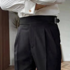 Black high-waisted pleated trousers with side buckle, worn by man | Chaps London