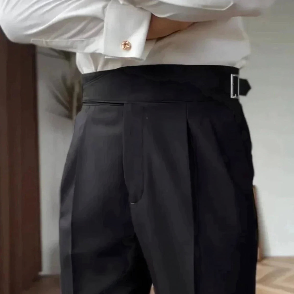 Black high-waisted pleated trousers with side buckle, worn by man | Chaps London