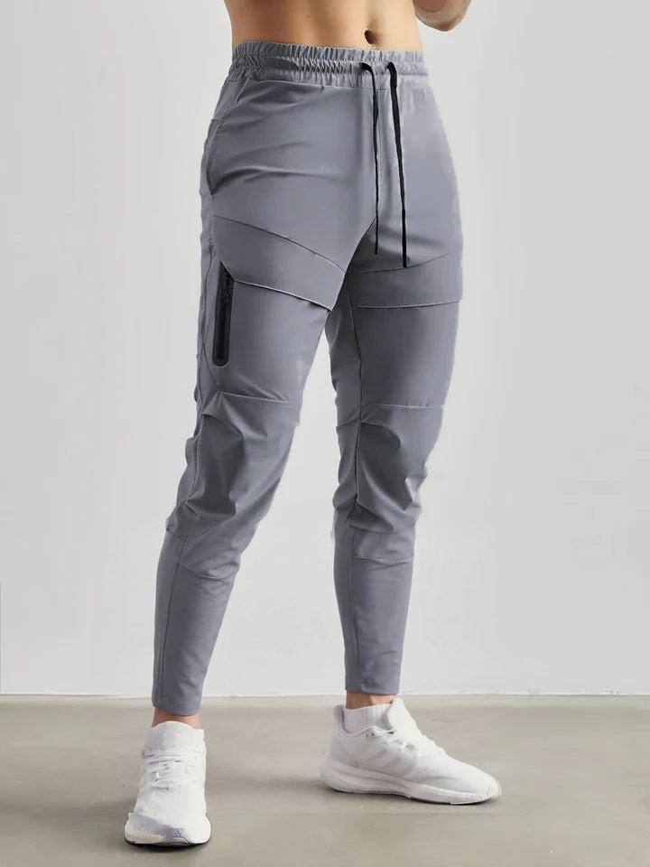 Gray stretch jogger sweatpants with zip pocket, worn by man standing | Chaps London