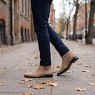 Tan suede Chelsea boots worn by man walking on leaf-covered pavement | Chaps London