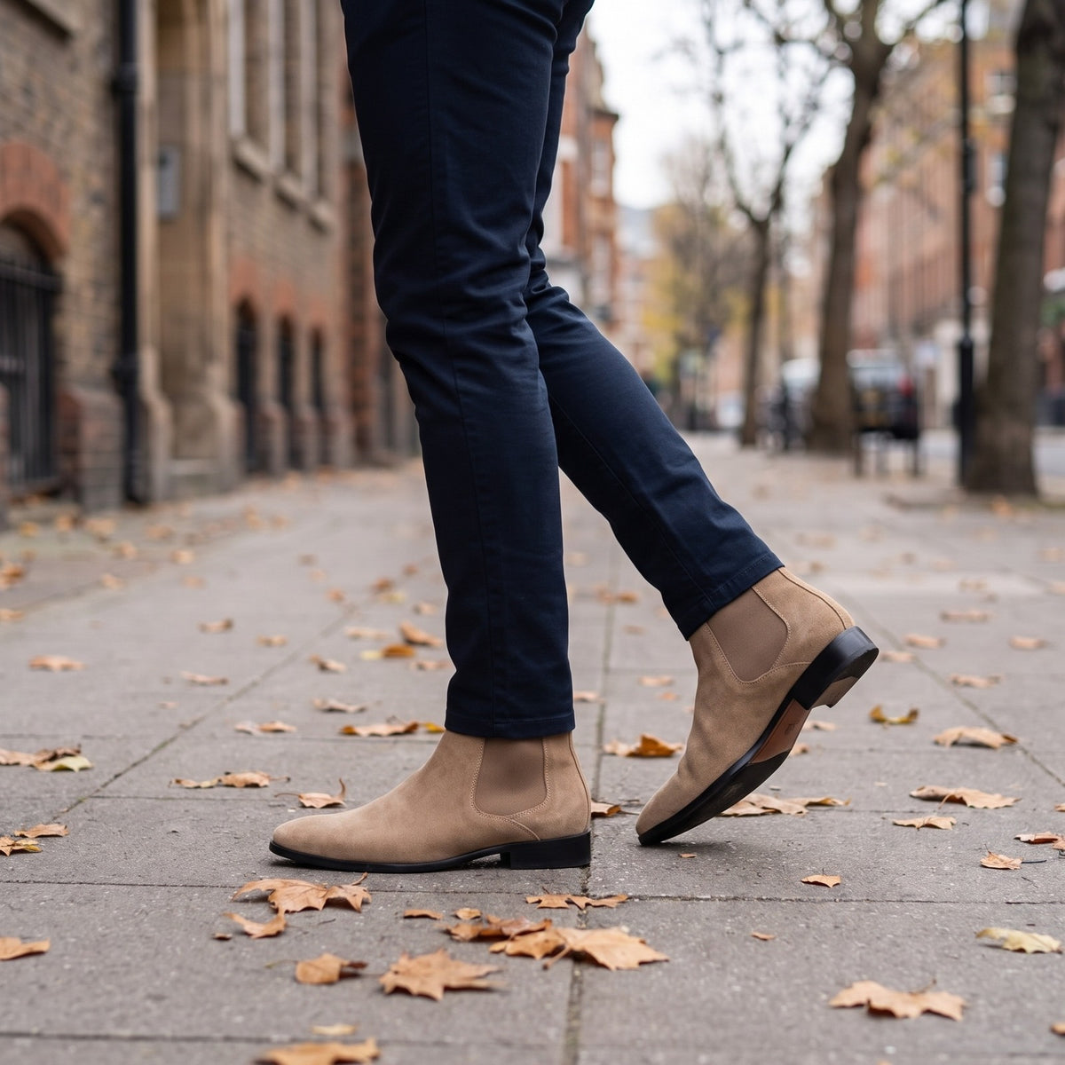 Tan suede Chelsea boots worn by man walking on leaf-covered pavement | Chaps London