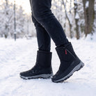 Black winter snow boot worn on person walking through snowy park | Chaps London