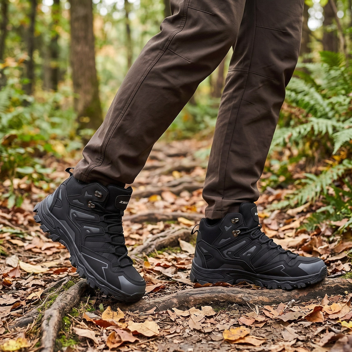 Man wearing black waterproof hiking boots walking on forested trail with leaves | Chaps London