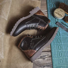 Black and brown lace-up ankle boots on green cutting mat, flat lay | Chaps London