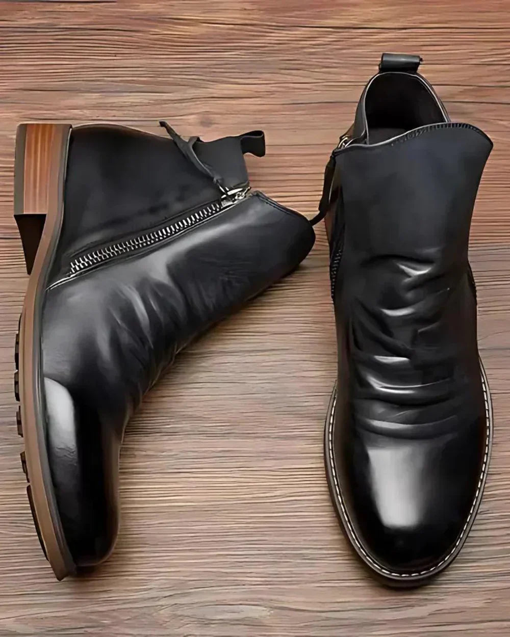 Black leather ankle boots with side zipper, shown flat on wood surface | Chaps London