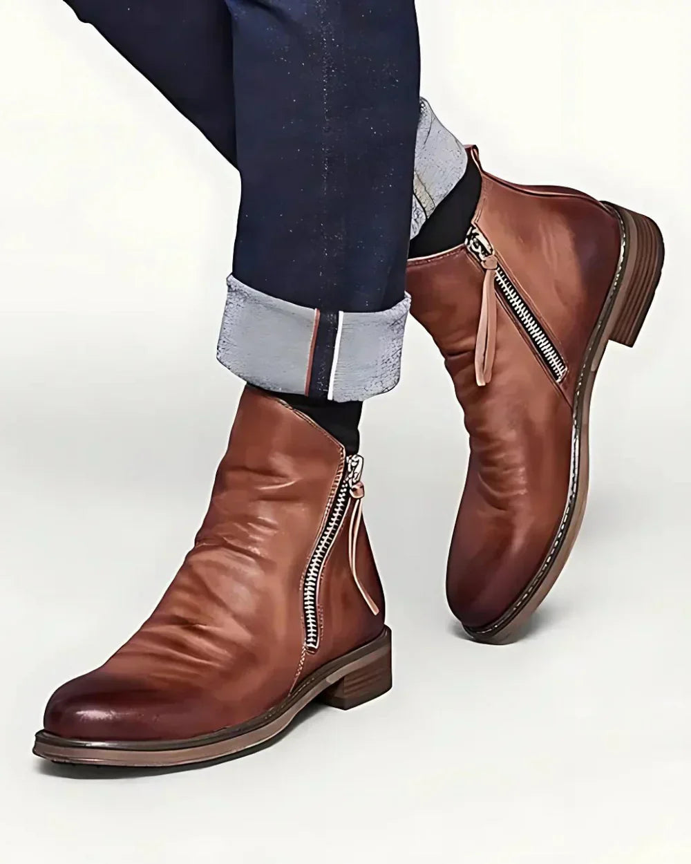 Brown leather ankle boots with side zippers worn by a person | Chaps London