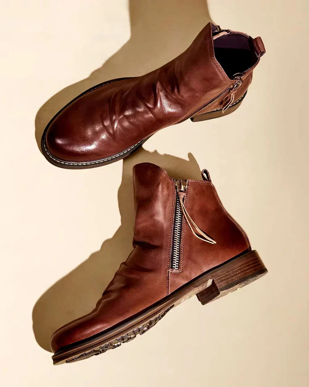 Brown leather ankle boots with side zipper, shown flat on surface | Chaps London
