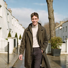 Men's long hooded raincoat in khaki, worn on a London street