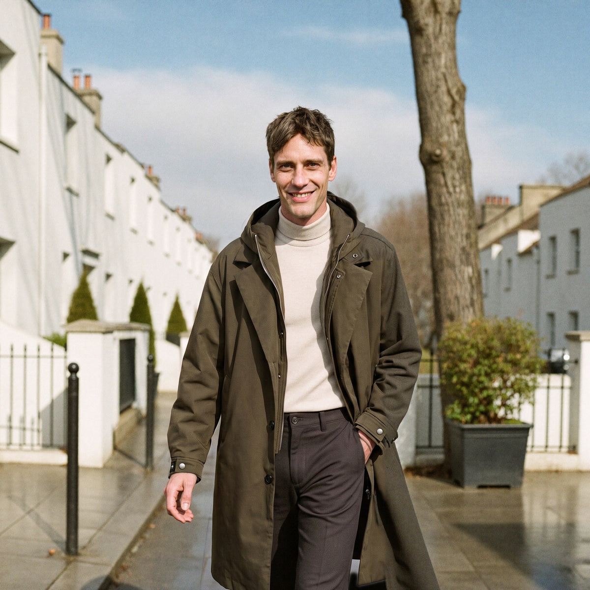 Men's long hooded raincoat in khaki, worn on a London street